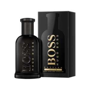 BOSS BOTTLED PARFUM fragrance bottle on a wooden surface with leaves in the background.
