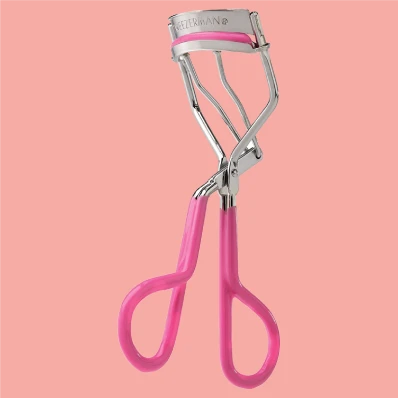 TWEEZERMAN Neon Great Grip Eyelash Curler in bright pink, designed for easy handling and precise curling. Rounded silicone pad gently curls lashes without pulling or tugging, leaving them looking fuller and more defined.
