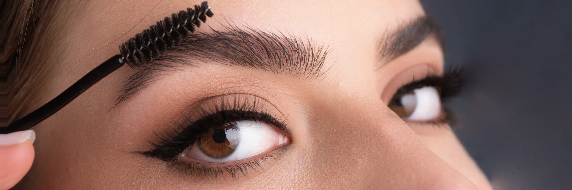 Woman applying mascara to her eyelashes