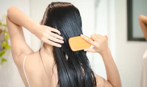 Woman using Ketoconazole Shampoo to comb her wet hair