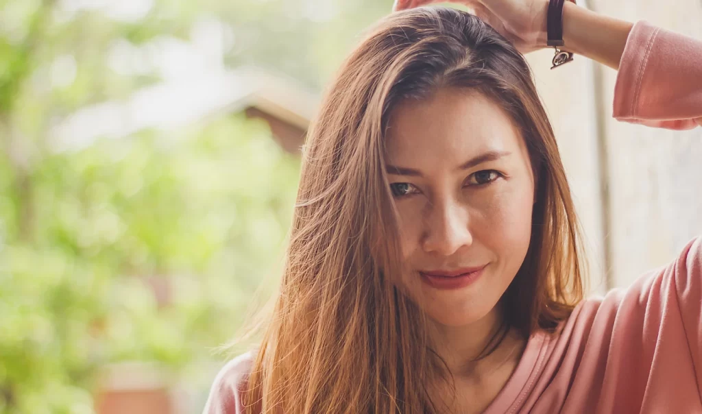 A woman with a radiant smile and Sunkissed Brown Hair.