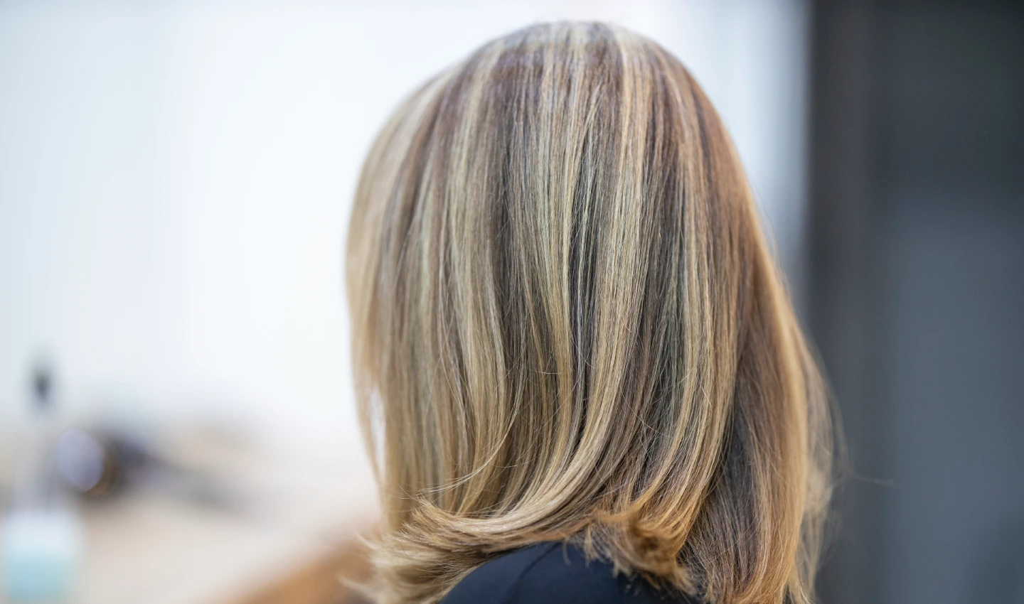 Image of a woman with Ash Metallic Blonde hair, styled in loose waves.