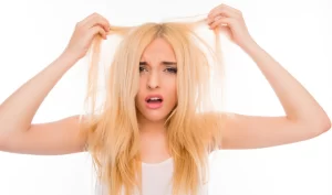 Photo portrait of upset woman looking at her damaged hair, emphasizing the importance of preventing split ends