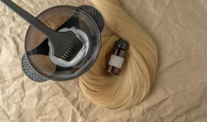 A container of sustainable hair dye, a brush, and some wigs.