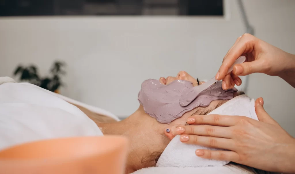 Close-up a woman receiving a facial mask treatment for over exfoliating by a cosmetologist.