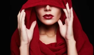 Red Lip Makeup: Woman wearing a hood, showcasing vibrant red lips