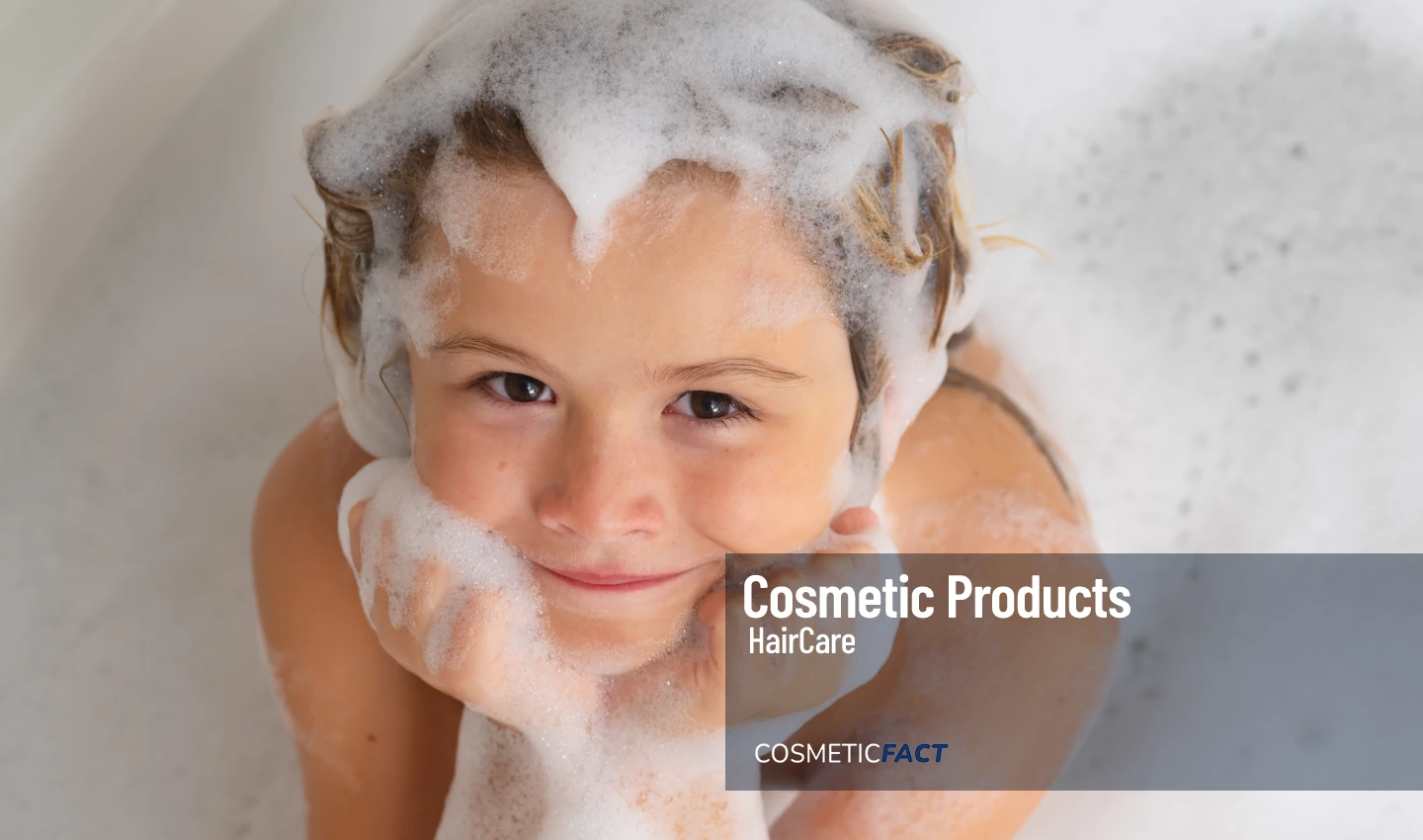 Child with shampoo foam and bubbles on hair enjoying a bath with Sulfate-Free Kids Shampoo