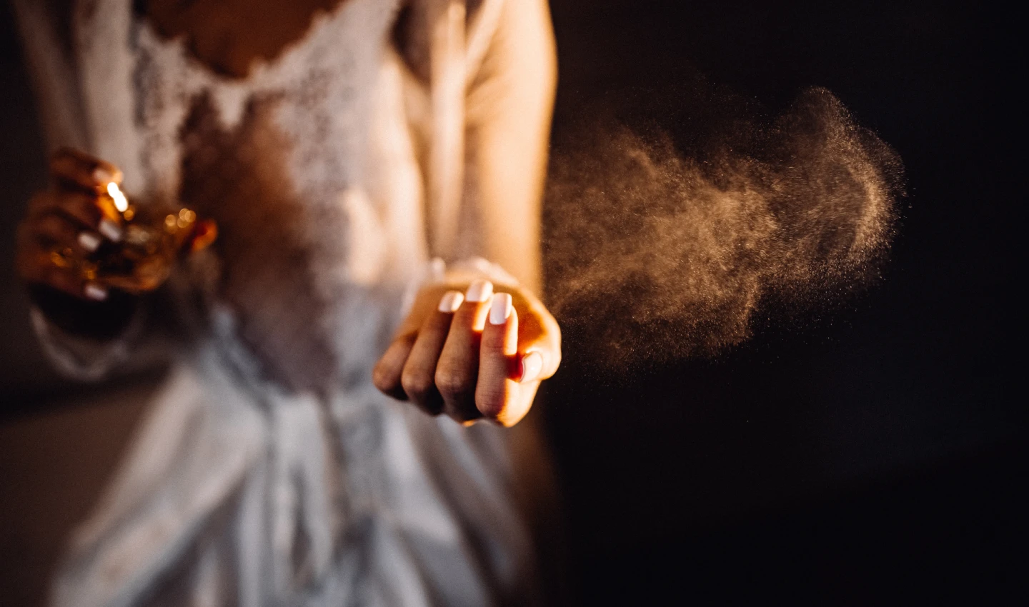 A woman spritzing perfume onto her wrist, embodying the transformative power of scent to boost mood and evoke positive memories