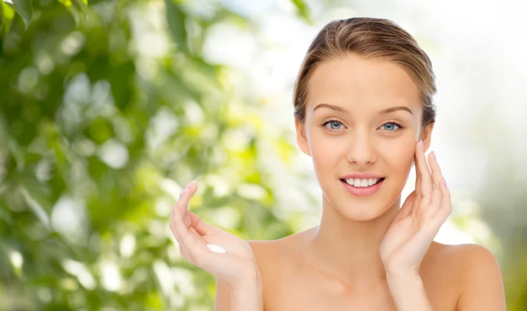 Portrait of a radiant woman with glowing skin, smiling at the camera in a serene setting, representing the positive effects of hormone balance on skin health