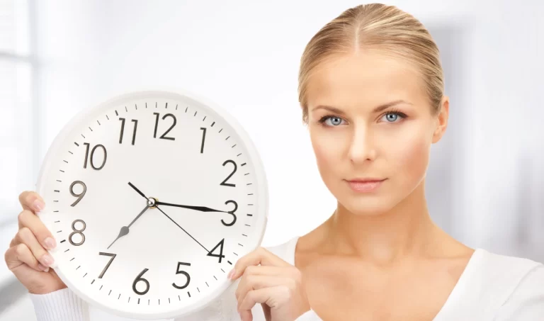 A stunning woman with glowing skin and a fit body, holding a clock in her hand.