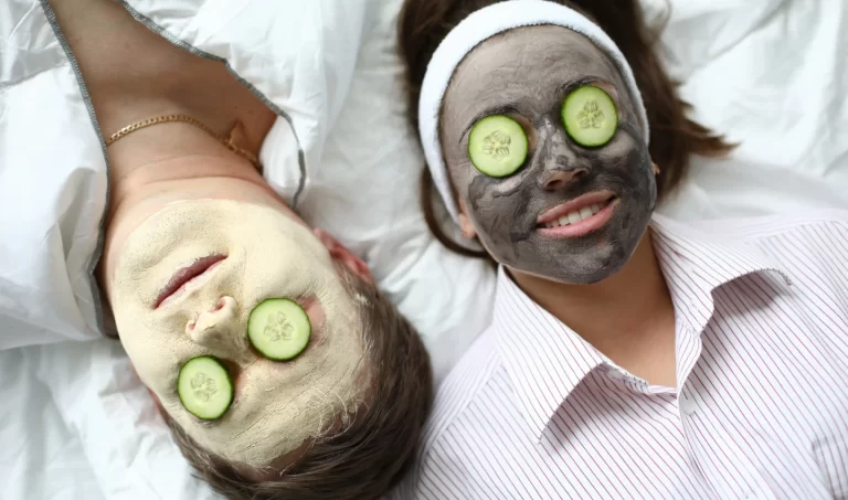 Two women relaxing at home with face and eye masks.