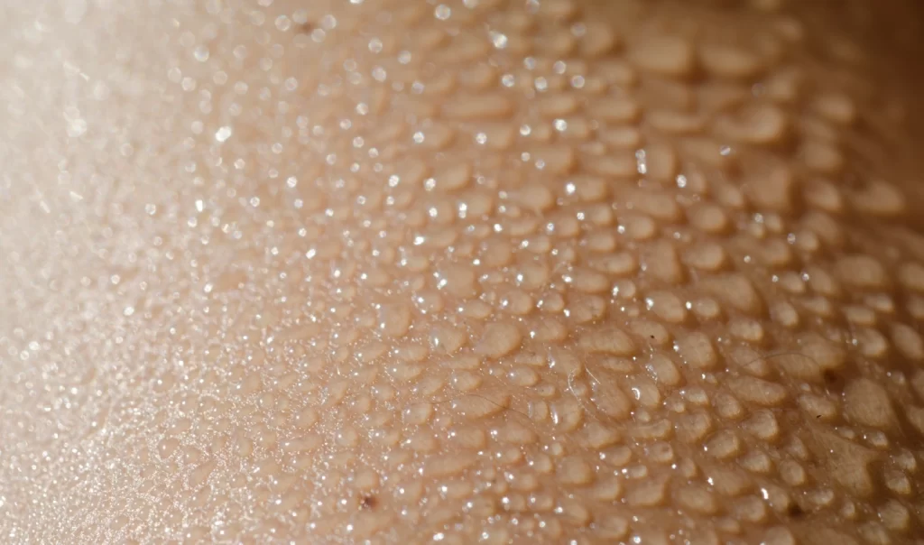 Droplets of water on skin, symbolizing hydration and even skin tone