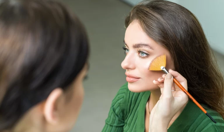 Young woman receiving makeup application to conceal under eye puffiness