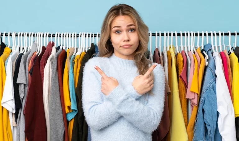 Image of a woman standing in front of a rack of clothes, pondering her wardrobe choices.