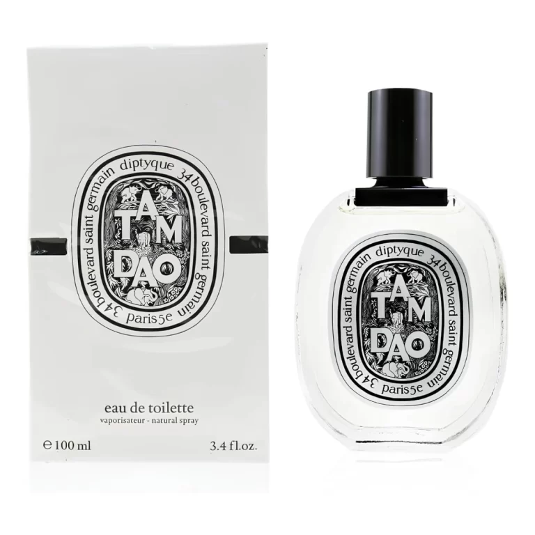 A close-up of a Diptyque Tam Dao Eau de Parfum bottle against a sand-colored background, evoking its warm, woody scent.